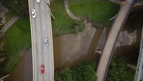 Ascending-drone-shot-of-cars-on-I-45-freeway-over-the-Buffalo-Bayou-near-downtown-Houston,-Texas