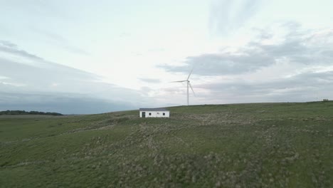 Low-aerial-approaches-building-and-hilltop-wind-turbine