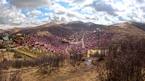 Panoramic-static-establishing-view-from-mountains-looking-down-on-Larung-Gar-Tibetan-Buddhist-academy-on-sunny-day