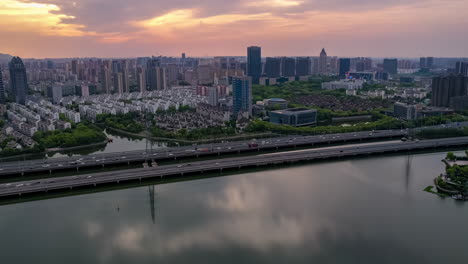 Real-estate-concept,-Residential-houses-and-apartment-in-a-suburb-near-River-with-lots-of-trees-between-houses,-with-the-lake-and-skyscrapers-landmark-building-n-the-background,-on-a-sunny-day-clouds