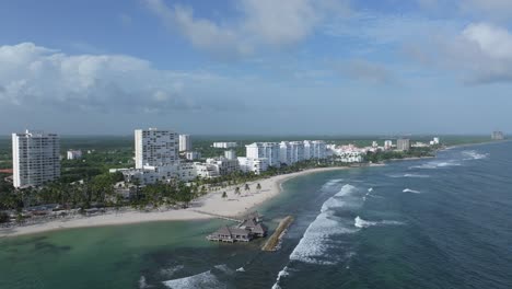 Panoramic-aerial-overview-of-waves-crashing-onto-beach-of-Playa-Hemingway-on-overcast-day