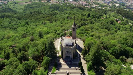 Aerial-view-of-Monte-da-Penha-church-amidst-lush-greenery-in-Guimarães,-Portugal