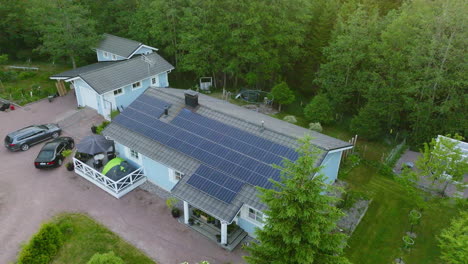 Vista-Aérea-Orbitando-Una-Casa-Unifamiliar-Con-Colectores-De-Luz-Solar,-Durante-El-Amanecer