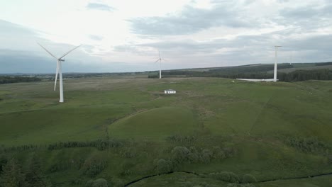 Aerial-descends-over-Whitelee-Windfarm-wind-turbines,-Scottish-moor