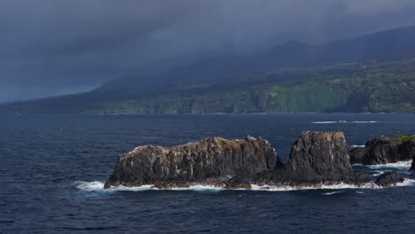 Flying-over-tall-eroded-basalt-rock-spires-off-coast-of-Maui-north-shore-from-road-to-Hana,-Hawaii