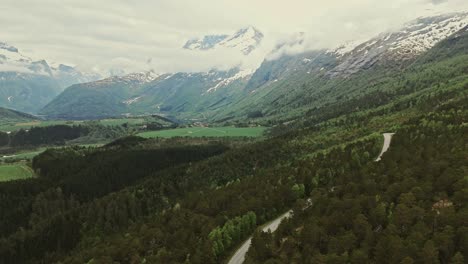 Winding-road-and-majestic-Norway-mountain-landscape,-aerial-view