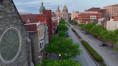 Toma-Aérea-Reveladora-De-Una-Calle-De-Estacionamiento-Con-El-Capitolio-Del-Estado-De-Pensilvania-De-La-Ciudad-De-Harrisburg-Al-Fondo.