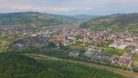 Drone-footage-of-sunny-Gura-Humorului,-showcasing-city-surrounded-by-nature