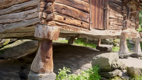 Old-wooden-home-ascended-above-ground-with-wood-pillars,-close-up