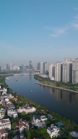 Edificio-Emblemático-En-El-Río-Saigon-Revelación-Panorámica-Con-Cielo-Azul-Claro-Drone-Vertical