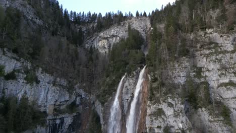 Waterfall-near-Swiss-Alps,-aerial-establish-shot-Seerenbach-Falls,-Switzerland