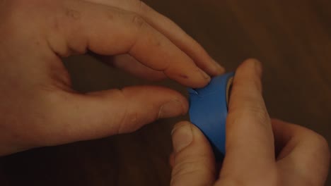 Unrolling-a-segment-of-blue-electric-tape
