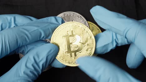 Hands-with-gloves-picking-Bitcoin-crypto-currency-coin