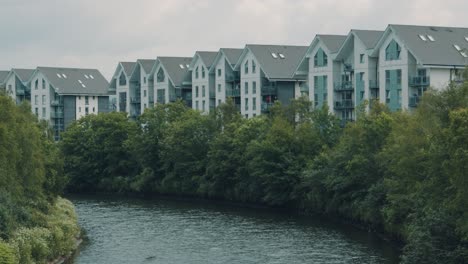 Bloques-De-Pisos-Junto-Al-Río-Con-Río-Tranquilo-Y-árboles