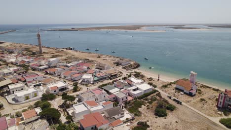 Farol-island,-olhão,-portugal,-showcasing-coastal-houses-and-clear-blue-waters,-aerial-view
