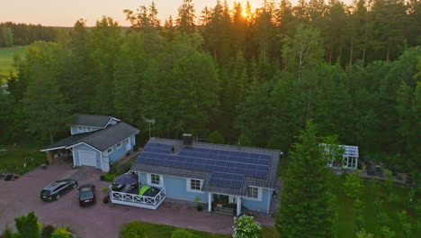 Aerial-view-rising-away-from-solar-powered-family-home,-sunrise-on-the-countryside