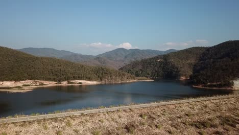 La-Toma-Del-Dron-Captura-Un-Lago-Sereno,-Con-El-Telón-De-Fondo-De-Una-Puesta-De-Sol.