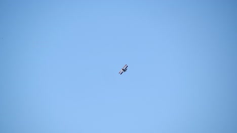 Low-Angle-View-of-an-Aerobatics-Biplane-in-Flight,-Blue-Sky-Backdrop