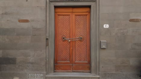 Aufnahme-Einer-Verzierten-Holztür-In-Rom,-Angekettet-Und-Mit-Einem-Vorhängeschloss-Versehen,-Durch-Verzierte-Türklopfer