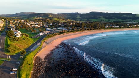 Landscape-drone-aerial-of-Gerringong-main-town-sandy-beach-ocean-waves-residential-street-neighbourhood-carpark-South-Coast-tourism-travel-Australia