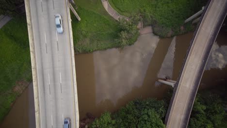 Ascending-shot-of-cars-on-freeway-over-the-Buffalo-Bayou-near-downtown-Houston,-Texas