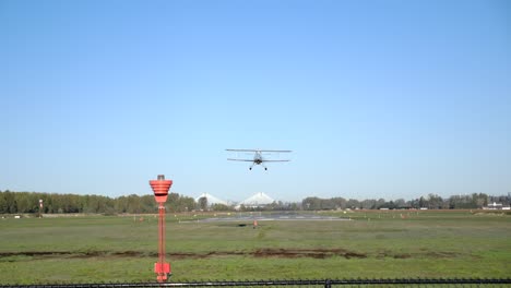 Rückansicht-Des-Propeller-Doppeldeckers-Bei-Der-Landung-Auf-Der-Landebahn---Sonniger-Tag