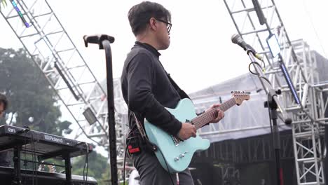 Miembro-De-La-Banda-Elegante-Tocando-La-Guitarra-En-El-Escenario-De-Un-Concierto-En-Vivo-Al-Aire-Libre