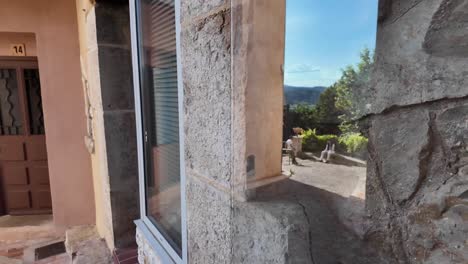 Window-reflecting-little-square-with-people-chatting-and-green-hills-ni-the-background