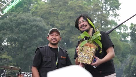 Musician-Bilal-Indrajaya-Posing-For-Photo-While-Holding-Potted-Plant-On-Stage