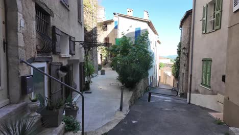 Walking-the-old-narrow-streets,-with-flowers-pots-everywhere,-old-stone-houses,-looking-up-on-blue-shutters