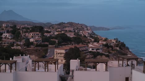 Toma-Panorámica-Desde-Una-Bonita-Ciudad-Española-En-La-Costa-Blanca-Hasta-El-Mar-Mediterráneo-En-Un-Atardecer-Nublado-Y-Colorido