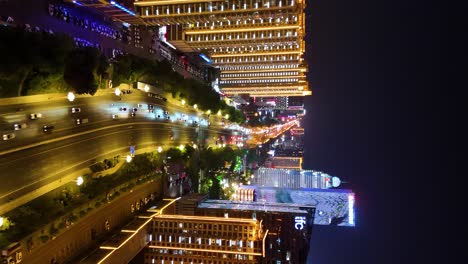 Slow-vertical-revealing-shot-of-apartments-and-a-busy-street-in-downtown-Linyi-City,-China