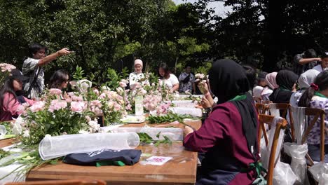 Grupo-De-Asiáticos-Trabajando-En-Arreglos-Florales-Para-Un-Concierto-Al-Aire-Libre