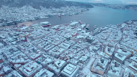 Rotierende-Drohnenaufnahme-Der-Schneebedeckten-Stadt-Bergen-In-Norwegen