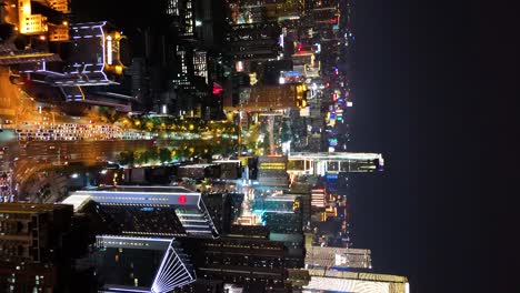 Aerial-revealing-shot-of-a-congested-street-in-downtown-Changsha-at-night-with-cityscape,-China