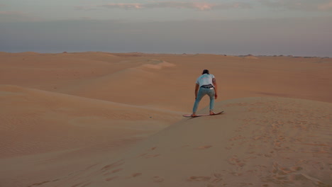 Hombre-Haciendo-Sandboard-Por-Una-Duna-En-El-Desierto-Del-Sahara-En-Cámara-Lenta
