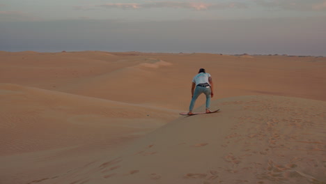 Man-sandboarding-down-a-dune-in-the-Sahara-Desert-in-slow-motion