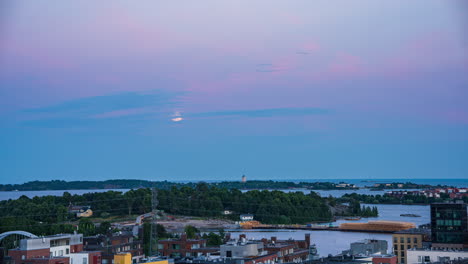 Timelapse-of-the-moon-moving-through-clouds-and-dusk-sky-above-the-Suomenlinna-island