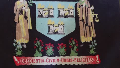 Tapestry-from-Dublin-City-Hall-with-Latin-inscription,-saints,-flowers,-and-castles