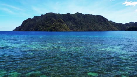 Niedrige-Luftaufnahme-über-Dem-Meer-Von-Coron-Mit-Blick-Auf-Die-Insel-Uson-Im-Zeitraffer