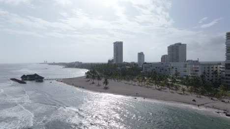 Die-Parallaxe-Der-Luftaufnahme-Konzentriert-Sich-Auf-Weiße,-Tropische-Apartmenthotels-Am-Meer-Mit-Blick-Aufs-Meer