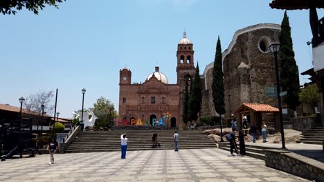 Daytime-timelapse-of-tourists-in-Tapalpa-city-center,-overlooking-Our-Lady-of-Guadalupe-church,-Jalisco,-Mexico