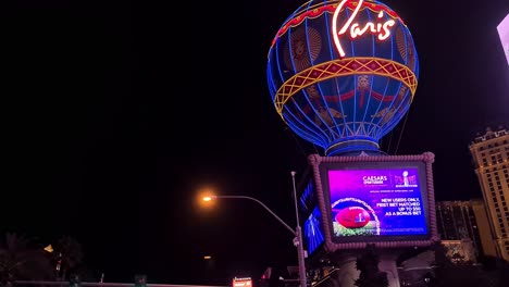 Las-Vegas-USA,-Driving-at-Night-Under-Paris-Casino-Hotel-Balloon,-Street-and-Traffic-Lights-on-Strip