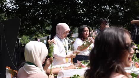 Young-Indonesian-Women-Preparing-Fresh-Flowers-For-Floral-Arrangement-At-Outdoor-Concert-Venue