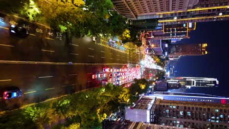 Vertical-aerial-revealing-shot-of-a-congested-street-in-downtown-Changsha-at-night,-China