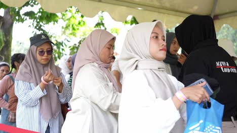 Security-Staff-Checking-Bags-Of-Spectators-At-Entrance-To-Outdoor-Concert-Event