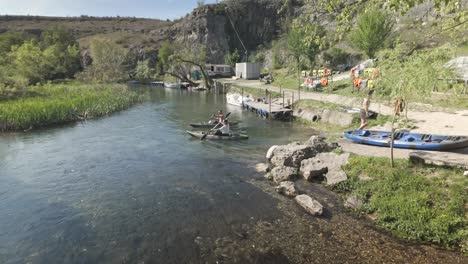 Couple-in-canoes-paddle-downstream-from-riverbank-Zlatna-Panega