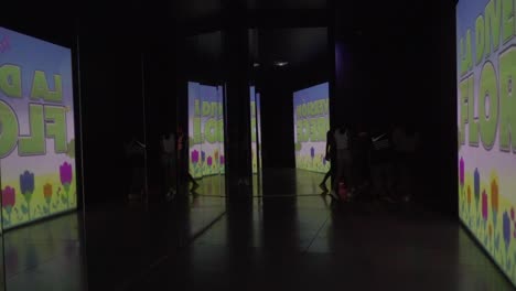 Tourists-walking-between-interactive-screens-in-aquarium-hallway