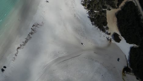 Aerial-top-down-of-car-on-Bremer-Beach-at-bay-during-sunny-day-with-shadow-of-clouds