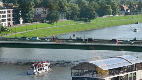 White-boat-going-under-the-Most-Dębnicki-with-car-on-the-top,-Krakow,-Poland